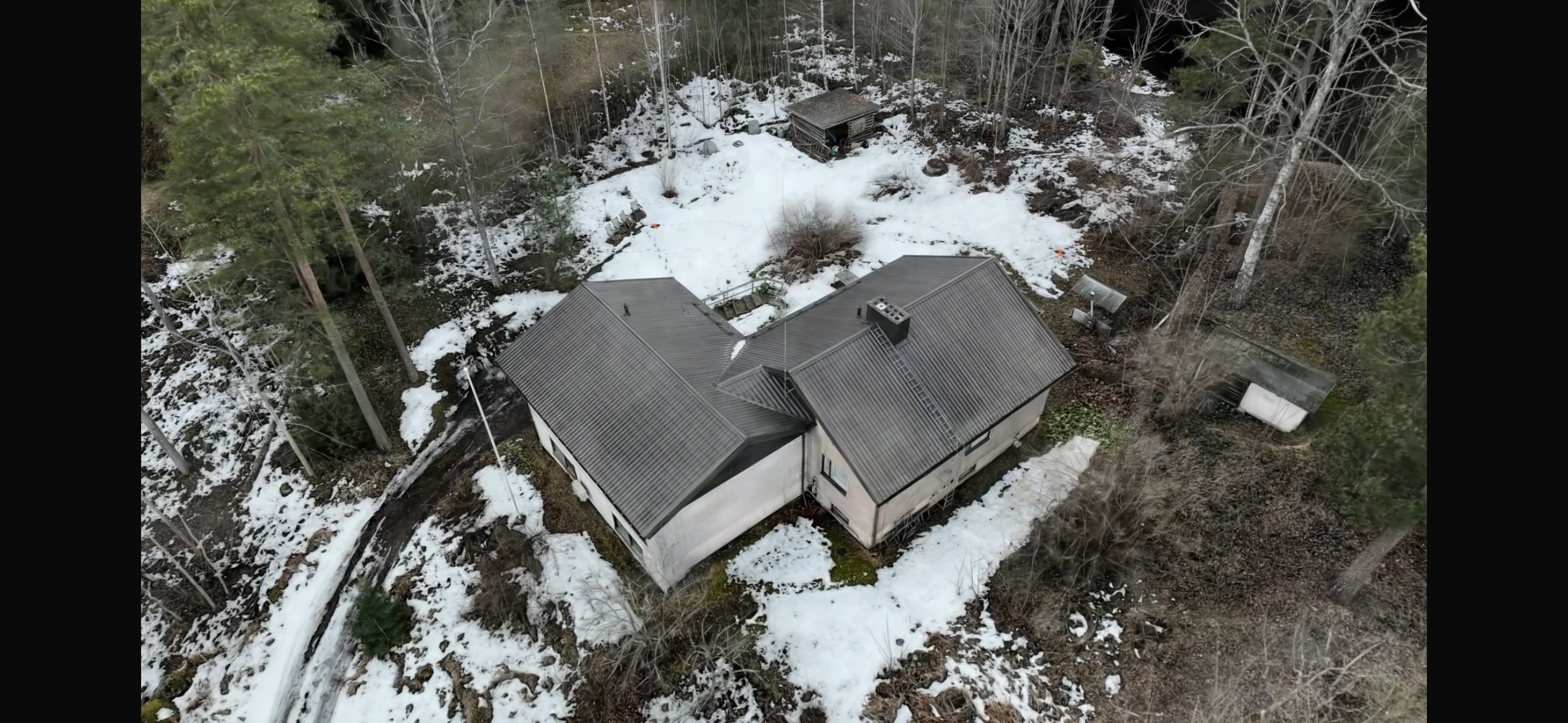 Gaussian splatting -malli omakotitalosta ja piharakennuksesta lumisessa metsämaastossa, tuotettu dronekuvista